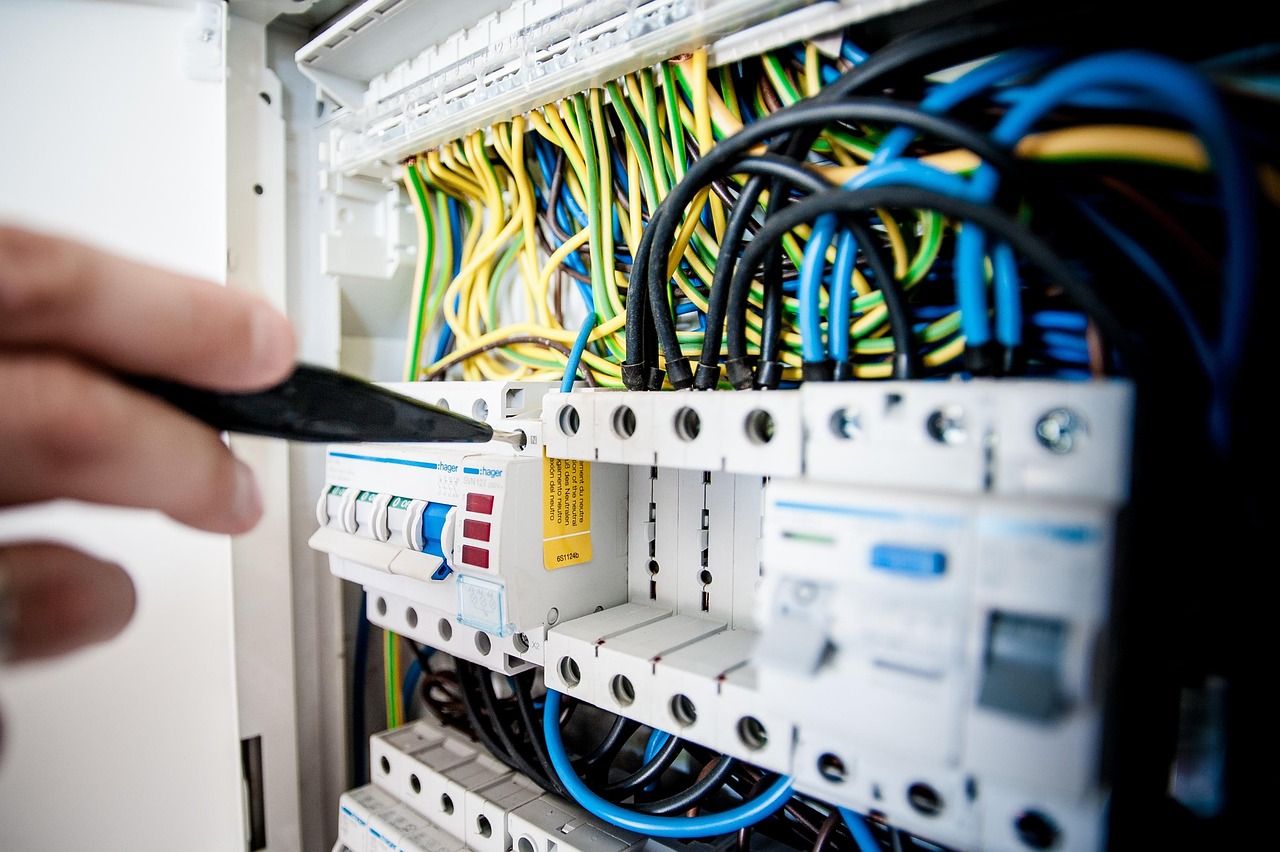 Electrician's hands working on a breaker panel